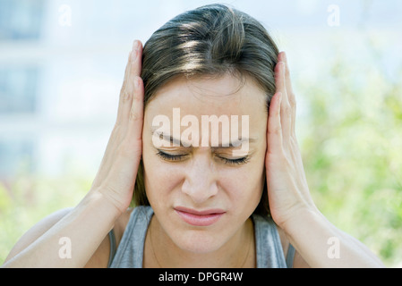 Distressed Frau mit Kopf in Händen Stockfoto