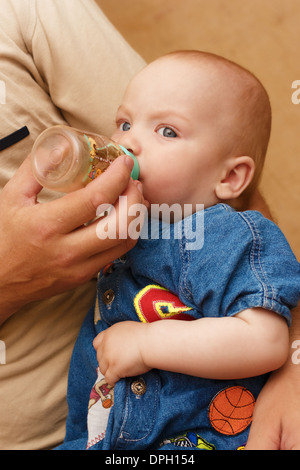 Der Mann füttert das Baby. Stockfoto