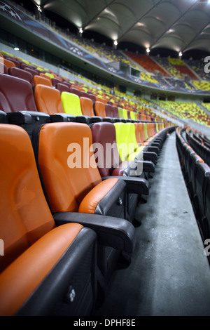 Leere Sitzreihen in verschiedenen Farben in einem Stadion Stockfoto