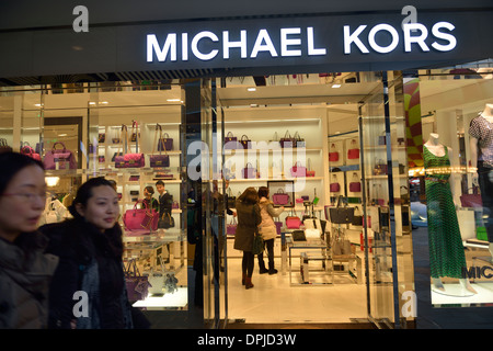 Die Menschen gehen Vergangenheit eine neu eröffnete Michael Kors speichern in Sanlitun, Peking, China. 11. Januar 2014 Stockfoto