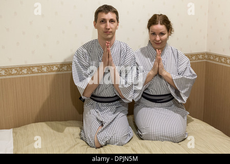 Kaukasische Pärchen sitzen in traditionellen Gewändern im Hotelzimmer im japanischen Stil, Japan Stockfoto