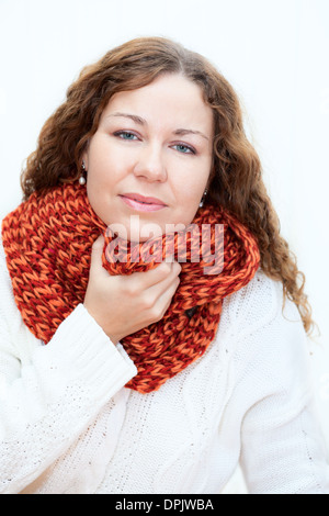 Junge Frau in warme Kleidung mit Halsschmerzen, weißer Hintergrund Stockfoto