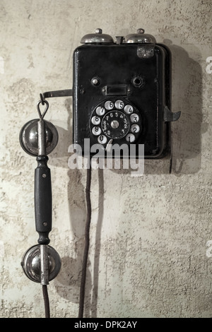 Vintage schwarze Telefon hängen alte graue Betonwand Stockfoto