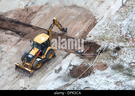 Arbeiten Sie mit der Überarbeitung der Heizung auf der anderen Straßenseite. Auffüllen der Gräben mit Sand von Traktor. Russland Stockfoto