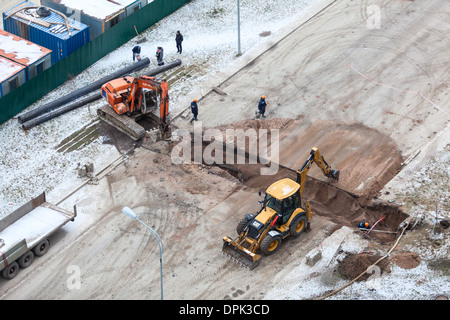 Arbeiten Sie mit der Überarbeitung der Heizung auf der anderen Straßenseite. Auffüllen der Gräben mit Sand von Traktor. Russland Stockfoto