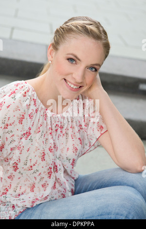 Portrait von junge Frau sitzt auf der Treppe Stockfoto