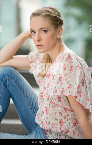 Portrait von junge Frau sitzt auf der Treppe Stockfoto