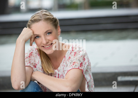 Portrait von junge Frau sitzt auf der Treppe Stockfoto