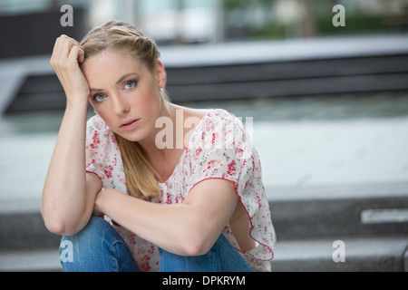 Portrait von junge Frau sitzt auf der Treppe Stockfoto