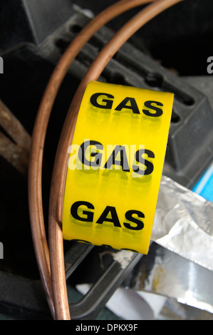 gelbe Gas Sicherheit Band mit einigen Kupferrohr Stockfoto