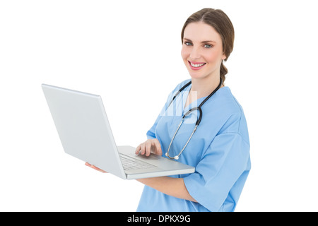 Junge Ärztin mit ihrem Notebook arbeiten und lächelt in die Kamera Stockfoto