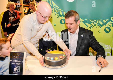 Belfast, Nordirland. 14. Januar 2014 - Kommandant Chris Hadfield mit einem "Solar System-Kuchen" präsentiert, wie er Exemplare seines Buches "An Astronaut Leitfaden zu Leben auf der Erde unterschreibt" Credit: Stephen Barnes/Alamy Live News Stockfoto