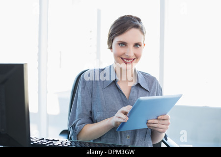 Porträt der attraktive junge Geschäftsfrau mit ihrem Tablet sitzt an ihrem Schreibtisch Stockfoto