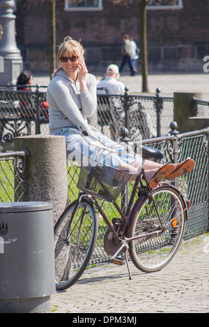 Dänemark, Kopenhagen, Radfahrer auf Handy auf Kongens Nytorv Stockfoto