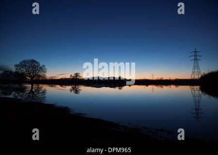 Die Sonne geht hinter den Malvern Hills in Worcester, spiegelt sich in überfluteten Ackerland Stockfoto