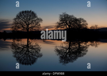 Die Sonne geht hinter den Malvern Hills in Worcester, spiegelt sich in überfluteten Ackerland Stockfoto