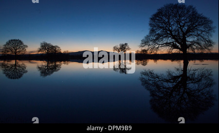 Die Sonne geht hinter den Malvern Hills in Worcester, spiegelt sich in überfluteten Ackerland Stockfoto