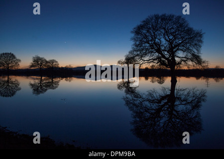 Die Sonne geht hinter den Malvern Hills in Worcester, spiegelt sich in überfluteten Ackerland Stockfoto