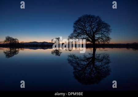 Die Sonne geht hinter den Malvern Hills in Worcester, spiegelt sich in überfluteten Ackerland Stockfoto