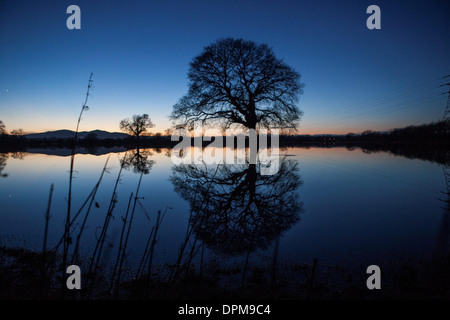 Die Sonne geht hinter den Malvern Hills in Worcester, spiegelt sich in überfluteten Ackerland Stockfoto