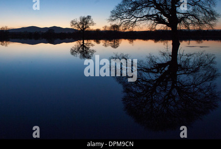 Die Sonne geht hinter den Malvern Hills in Worcester, spiegelt sich in überfluteten Ackerland Stockfoto