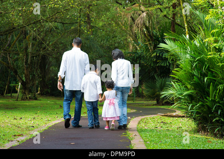 Indische Familie im Freien. Rückansicht von Eltern und Kindern zu Fuß auf Gartenweg. Natur, Freizeit Lifestyle zu erforschen. Stockfoto