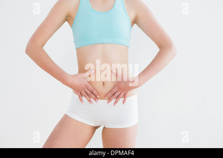 Fit Woman Hände auf Bauch Wand Stockfoto