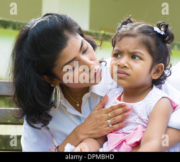 Indische Familie im Freien. Moderne Mutter ist ihre schreiende Tochter trösten. Stockfoto