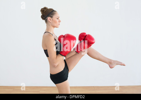 Frau trägt rote Boxhandschuhe posiert getönt Stockfoto