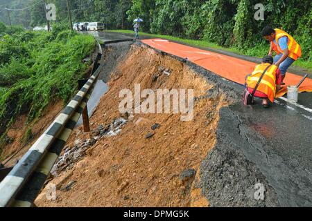 Kota Kinabalu, Sabah, Malaysia. 15. Januar 2014. Notfall-Service arbeiten auf dem Gelände einer eingestürzten Straße in Sabah, Malaysia, 15. Januar 2014. Monsunklima brachte Tage Regen und überflutete Gewässer in Malaysia Sabah, wodurch mehrere Erdrutsche und mehrere Verkehrs Stillstand. (Xinhua/Alamy Live-Nachrichten) Stockfoto