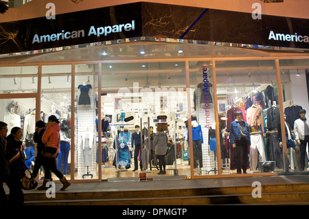 Die Menschen gehen vorbei an einem American Apparel Store in Sanlitun, Peking, China. 11. Januar 2014 Stockfoto