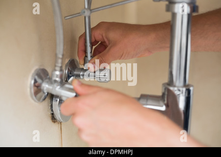 Nahaufnahme von einem Klempner Hände und Waschbecken Abfluss Stockfoto