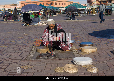 Snake Charmer mit einer ägyptischen Kobra (Naja Haje) in Djemaa el-Fna Platz in Marrakesch, Marokko Stockfoto