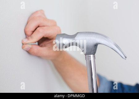 Nagel in die Wand Hämmern Hände Stockfoto