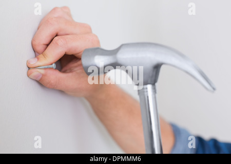 Nagel in die Wand Hämmern Hände Stockfoto