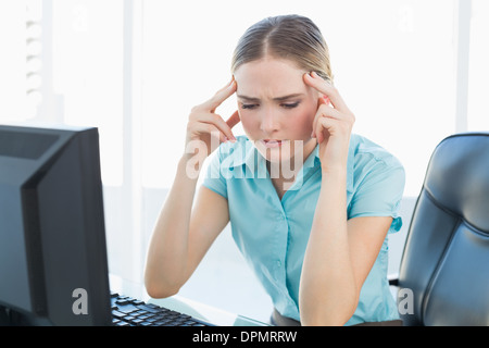 Edel grimassierende Geschäftsfrau mit Kopfschmerzen Stockfoto