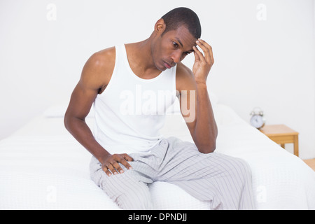 Afro Mann leidet unter Kopfschmerzen im Bett Stockfoto