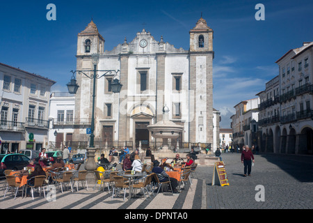 Évora Praça do Giraldo Platz mit Menschen am Café Cafés Tische und Kirche Igreja da Santo Antão Alentejo Portugal Stockfoto