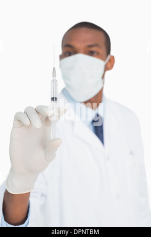 Männlichen Arzt in Maske und Handschuhe halten eine Injektion Stockfoto