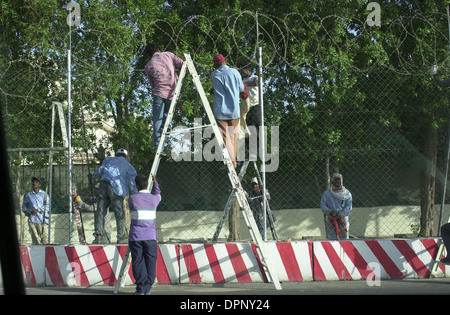 Arbeitnehmer, die Installation von Stacheldraht und andere Sicherheitsmaßnahmen auf den Umfang einer Verbindung Gehäuse Ausländer und Westler. Stockfoto