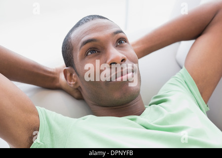 Nachdenklicher entspannte junge Afro Mann auf sofa Stockfoto