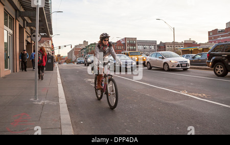 Eine Frau fährt ihr Fahrrad in einem ausgewiesenen Radweg in Boston. Stockfoto