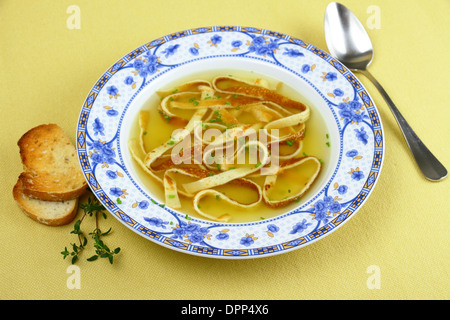 Pfannkuchen-Suppe in blaue Platte mit Brot, horizontale Stockfoto