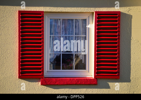 Rote Witwe Fensterläden auf alte Hütte Stockfoto