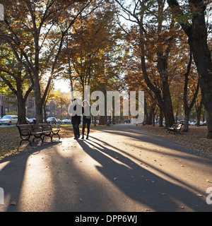 Ein Mann und eine Frau gehen gemeinsam auf Commonwealth Avenue Mall in Boston. Stockfoto