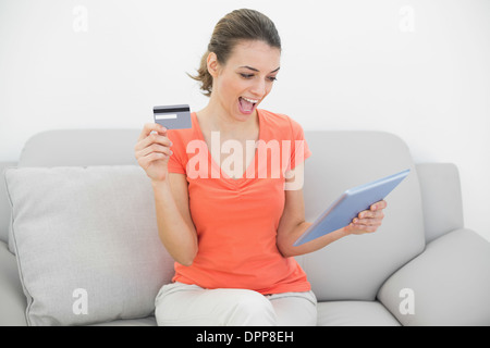 Attraktive Frau, die ihre Kreditkarte halten Sie ihr tablet Stockfoto