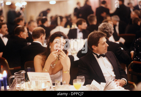 Lippenstift, eine Frau, die Lippenstift aufzieht, während einer Pause bei einem Auktionsessen City of London mit schwarzer Krawatte ihr Make-up macht. 1990s UK 1992 England . England HOMER SYKES Stockfoto