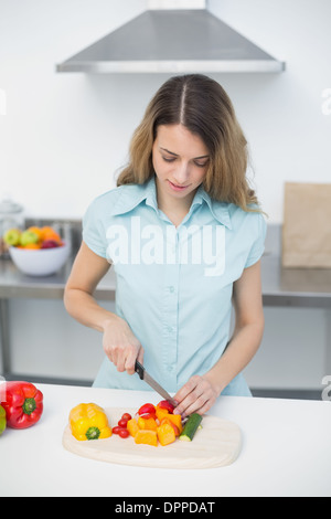 Konzentrierte sich die junge Frau in der Küche Schneiden von Gemüse Stockfoto