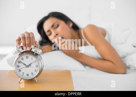 Schöne gähnende Frau der Retro-Wecker ausschalten Stockfoto