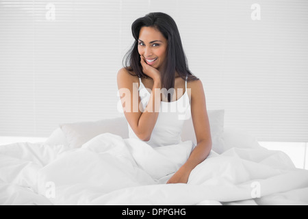 Wunderschöne junge Frau posiert auf ihrem Bett sitzen Stockfoto